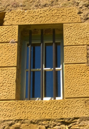 Fenêtre du logis avec un encadrement en bossage vermiculé - © PCB
